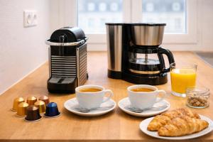 a coffee maker and two cups of coffee and pastries at Le Mans Cosy in Le Mans +6 photos