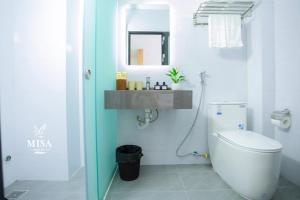 a bathroom with a white toilet and a sink at MISA Hotel in Dong Hoi +26 photos