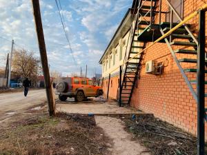 an orange jeep parked next to a brick building at Halqyma Hotel in Oral