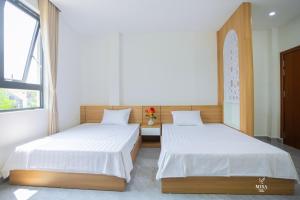 two beds sitting next to each other in a room at MISA Hotel in Dong Hoi