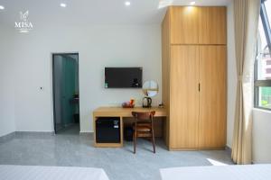 a room with a desk with a television and a chair at MISA Hotel in Dong Hoi