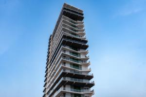 a tall apartment building against a blue sky at Luxurious 2 bedroom condo with partial ocean view in Mazatlán