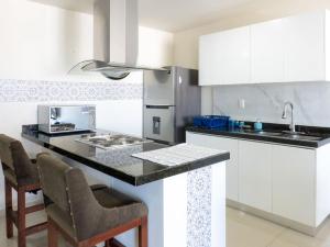 a kitchen with white cabinets and a black counter top at Luxurious 2 bedroom condo with partial ocean view in Mazatlán +63 photos