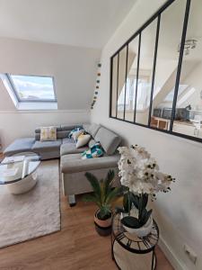 a living room with a couch and a table at Superbe cocon de 44m2 in Longvic