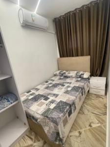 a small bedroom with a bed and a air conditioner at Leila Home Garden - Maamourah Beach in Alexandria