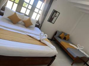 a bedroom with a bed with white sheets and pillows at Regal Montara in Nuwara Eliya