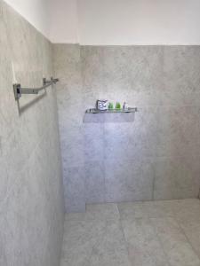 a bathroom with a shower with a shelf on the wall at Regal Montara in Nuwara Eliya +69 photos