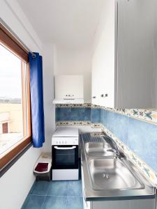 a kitchen with a sink and a stove at Nonna Liberina in Procida