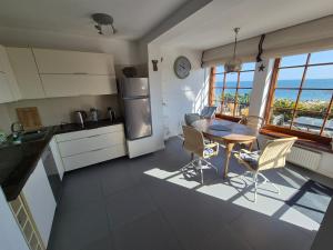 a kitchen with a table and chairs and a view of the ocean at Chata rybacka w Orłowie / Apartament in Gdynia