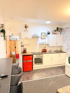 eine Küche mit weißen Schränken und roten Geräten in der Unterkunft Backpackers Blackpool Hotel & Suites in Blackpool