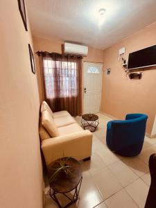 a living room with a white couch and a blue chair at Arroyito Depto Pequeño in Tuxtla Gutiérrez