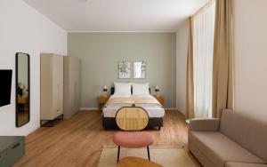 a bedroom with a bed and a couch at Limehome Kaiserslautern Rummelstr in Kaiserslautern +40 photos