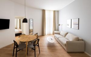 a living room with a couch and a table and chairs at Limehome Kaiserslautern Rummelstr in Kaiserslautern