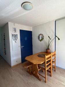 a dining room with a wooden table and a blue door at Charmant appartement avec vue montagne in Luz-Saint-Sauveur