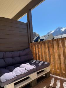 a couch sitting on the back of a balcony at Charmant appartement avec vue montagne in Luz-Saint-Sauveur