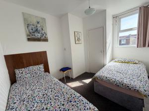 a bedroom with two beds and a window at Melrose Hotel in Blackpool