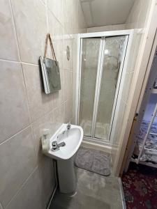a small bathroom with a sink and a shower at Melrose Hotel in Blackpool