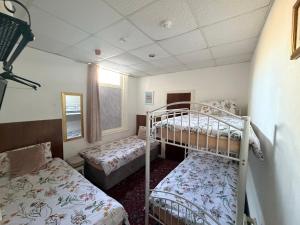 a bedroom with two bunk beds and a window at Melrose Hotel in Blackpool +47 photos