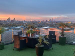 a table and chairs on a balcony with a view of a city at The London Skyline Penthouse in London +20 photos