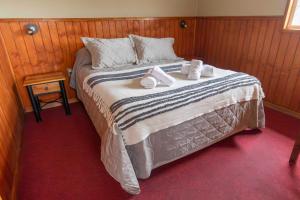a bedroom with a large bed with towels on it at Cabañas Lago Tyndall in Torres del Paine