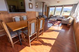a dining room with a wooden table and chairs at Cabañas Lago Tyndall in Torres del Paine