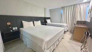 a hotel room with two beds and a window at Natal Plaza Hotel in Natal +18 photos
