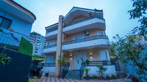 a white house with a porch and stairs at 7even Boutique Hostel in Tirana