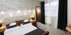 a bedroom with a bed and a brick wall at Apartamenty Blisko Centrum in Toruń