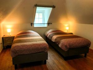 zwei Betten in einem Zimmer mit einem Fenster und zwei Lampen in der Unterkunft Unieke vakantiewoning met jacuzzi in de natuur in Het Laar