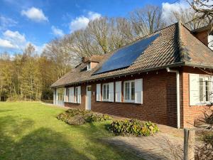 ein Haus mit einem Solarpanel auf dem Dach in der Unterkunft Unieke vakantiewoning met jacuzzi in de natuur in Het Laar