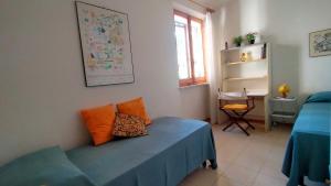 a bedroom with a blue bed with an orange pillow on it at TRILOCALE CON GIARDINO E POSTO AUTO- cod 504 in Marcelli +10 photos