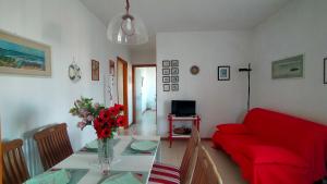 a living room with a red couch and a table at TRILOCALE CON GIARDINO E POSTO AUTO- cod 504 in Marcelli