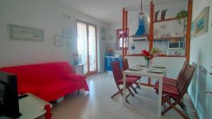 a living room with a red couch and a table at TRILOCALE CON GIARDINO E POSTO AUTO- cod 504 in Marcelli