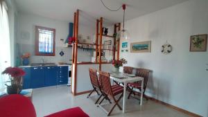 a kitchen with a table and chairs in a room at TRILOCALE CON GIARDINO E POSTO AUTO- cod 504 in Marcelli
