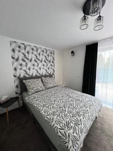 a bedroom with a bed with a black and white comforter at Apartament tatarski PARKING! in Przemyśl