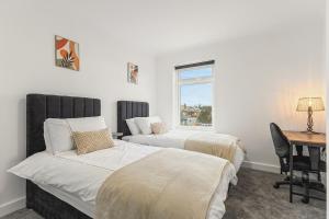 a bedroom with two beds and a desk and a window at Potovens Place in Lofthouse Gate