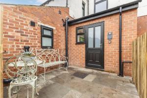 a patio with two chairs and a black door at Potovens Place in Lofthouse Gate