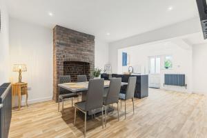 a dining room with a table and chairs and a fireplace at Potovens Place in Lofthouse Gate