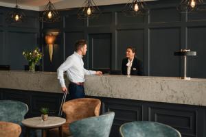 a man and a woman standing at a counter at Waterford Viking Hotel in Waterford