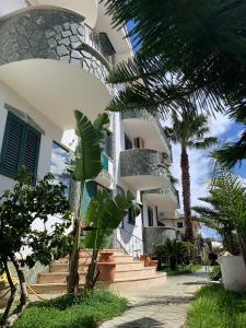 a house with a palm tree in front of it at Don Michele Apartments in Gizzeria