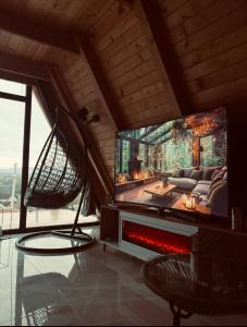 a living room with a flat screen tv and a fireplace at Vila Ahouse in Jagodina