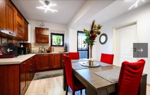 a kitchen with a wooden table and red chairs at Apartament Kalinderu K2 Busteni in Buşteni