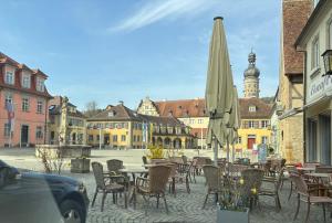 an empty street with tables and chairs and an umbrella at Junges Wohnen zwei in Weikersheim +2 photos