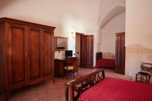 a room with a bedroom with a bed and a desk at Antica Masseria Jorche in Torricella +45 photos