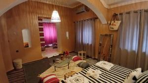 a living room with a bed and a table at La Colline Verte Dar Ait El Abass in Ouarzazate
