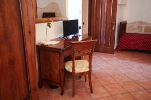 a desk with a computer and a chair in a room at Antica Masseria Jorche in Torricella