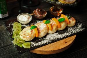 a plate of food with buns with fruit and sauce at Chillout Dorm Cracow by BookingHost in Krakow