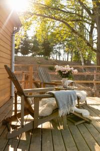 a table and chairs on a deck with a vase of flowers at Farma Mlýn Drásov in Drásov