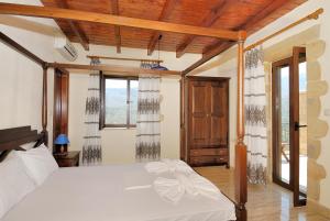 a bedroom with a white bed and some windows at Villa Georgia in Fílippos