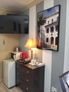 a room with a refrigerator and a desk with a lamp at Petit Hôtel Amara in La Malbaie